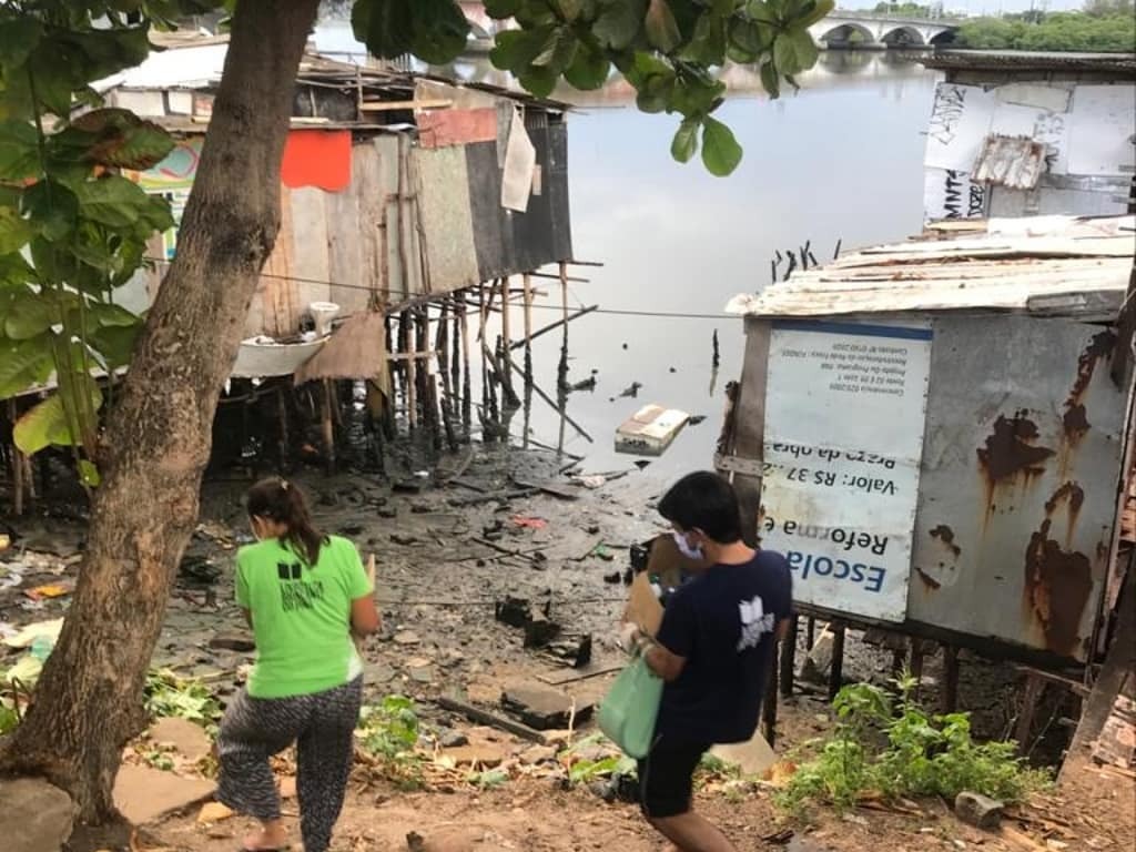 Entrega de alimentos na comunidade de palafitas ao lado da ponte do Pina